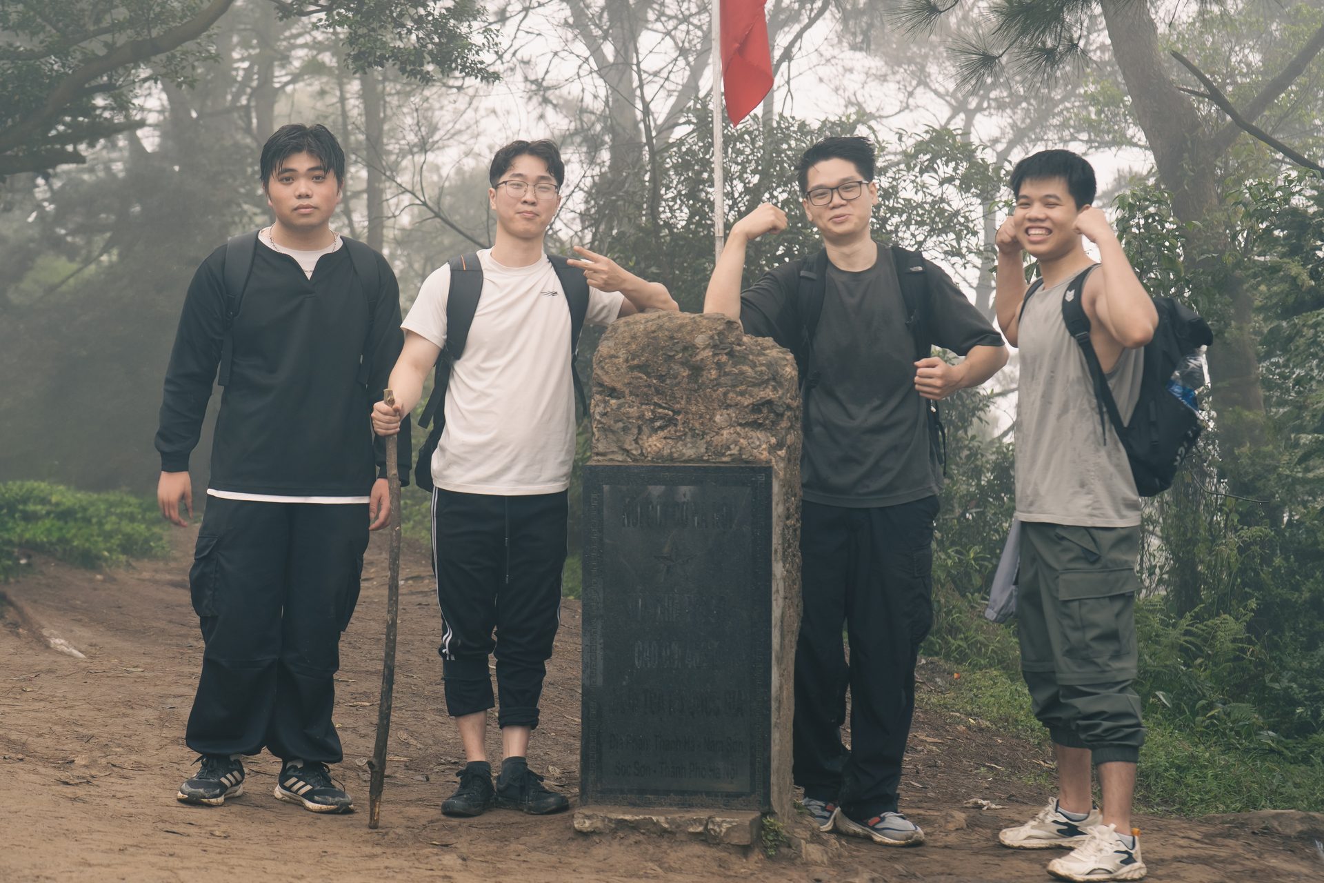 Our hiking group beside the summit marker in the mist