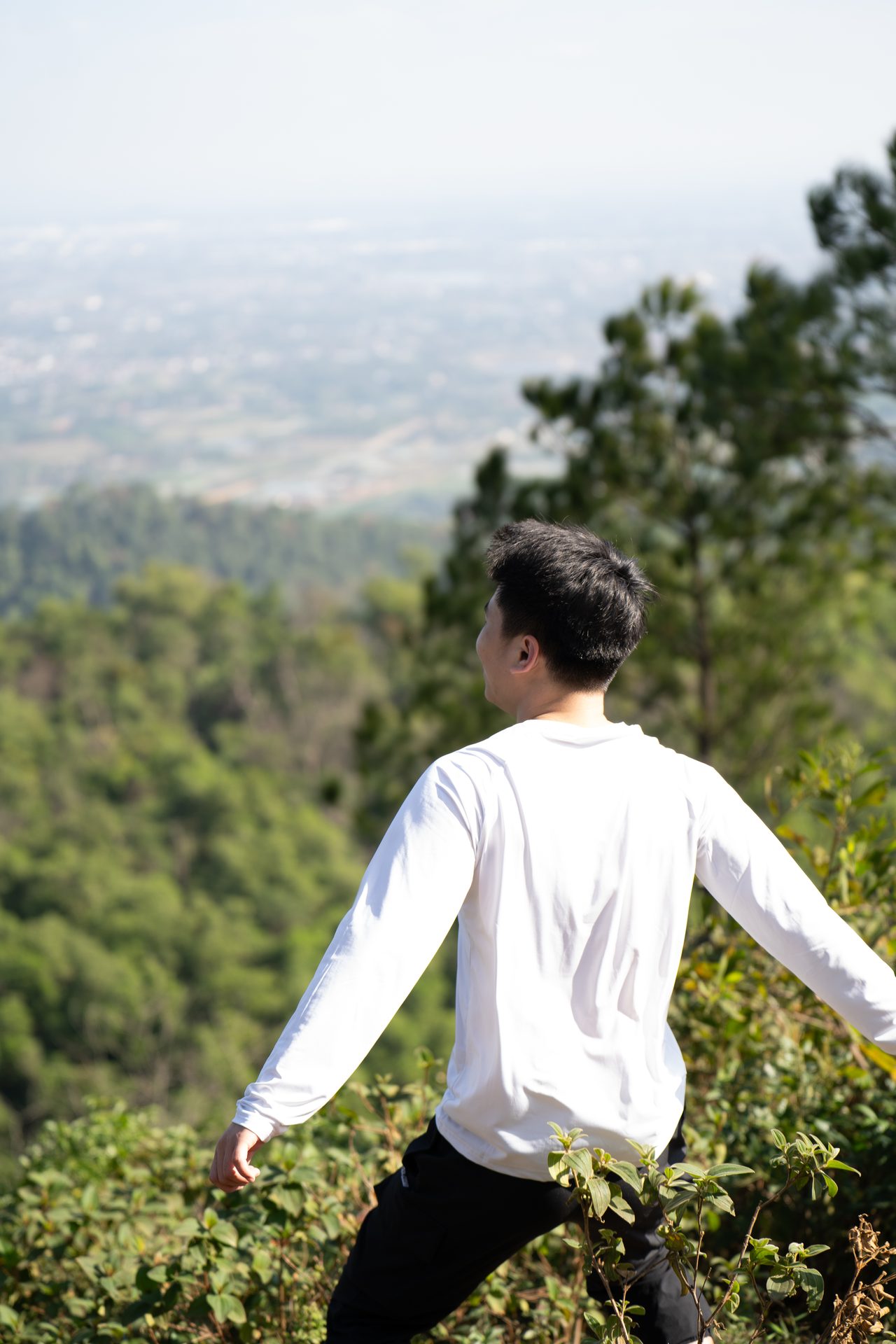 A hiker pauses to take in the view over the green hills and lowlands