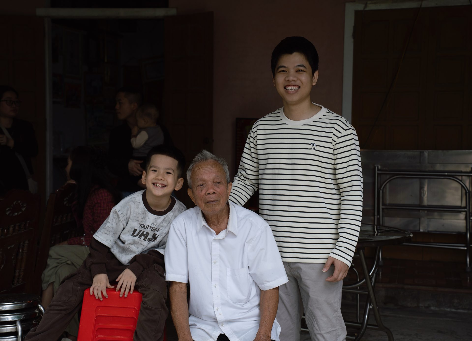 A family portrait of my cousin, my grandfather, and me